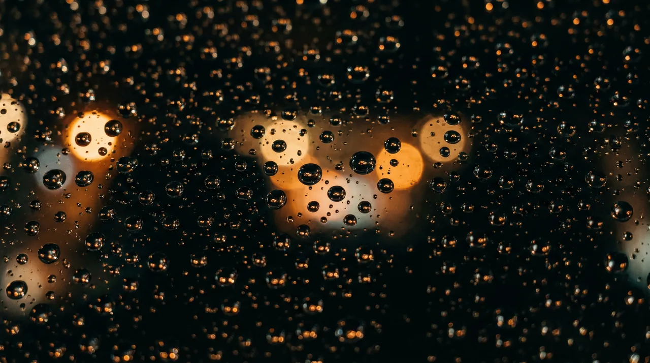 Gouttes d'eau qui perlent sur un pare-brise traité hydrophobe InterCar sous la pluie