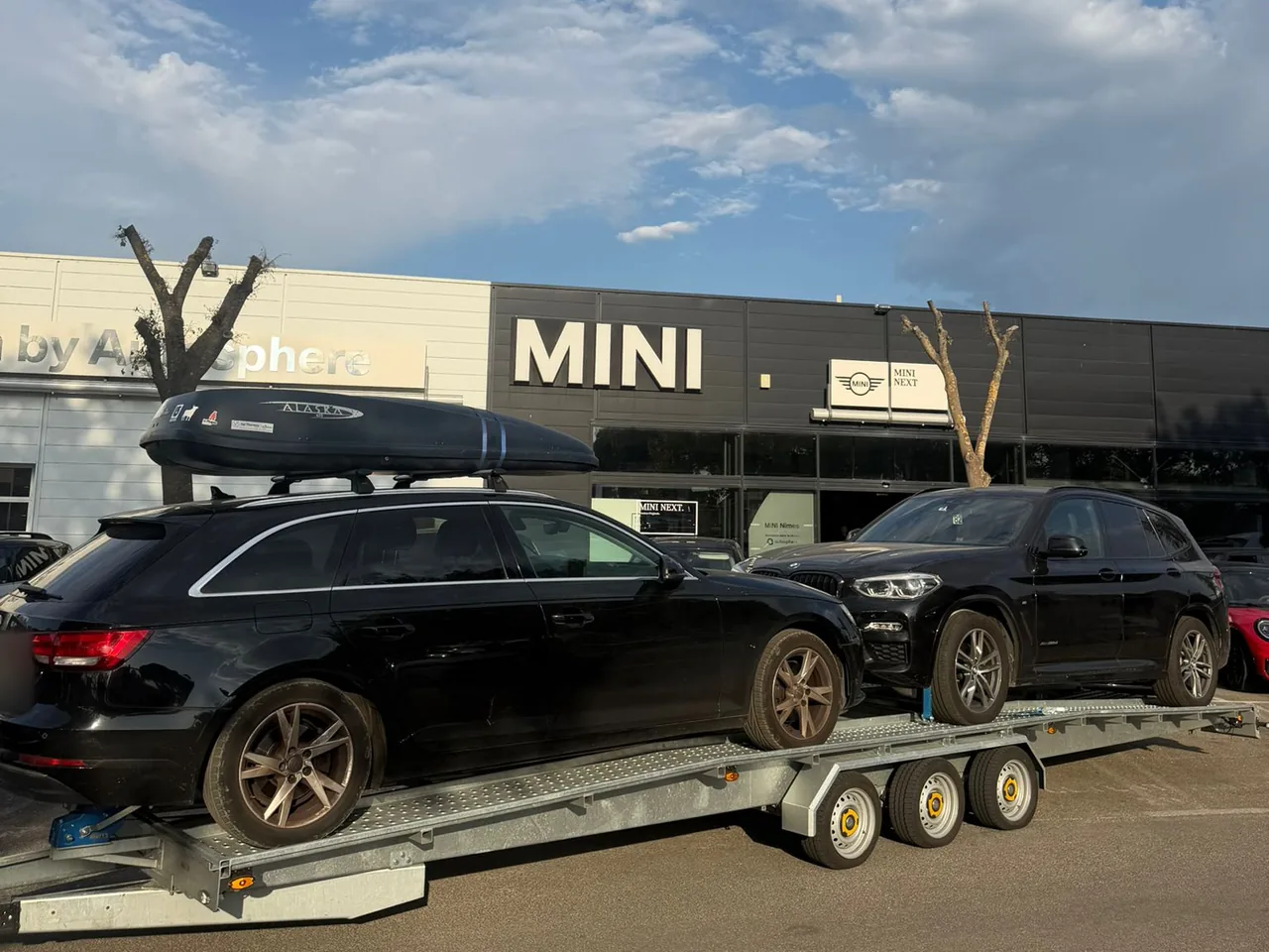 Audi A4 Avant et BMW X3 livrés sur remorque porte-voiture devant la concession MINI de Nîmes