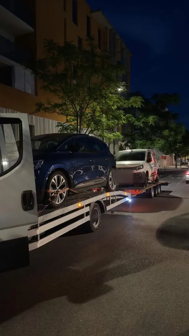 Renault Captur et Peugeot Partner chargés de nuit sur une remorque porte-voiture