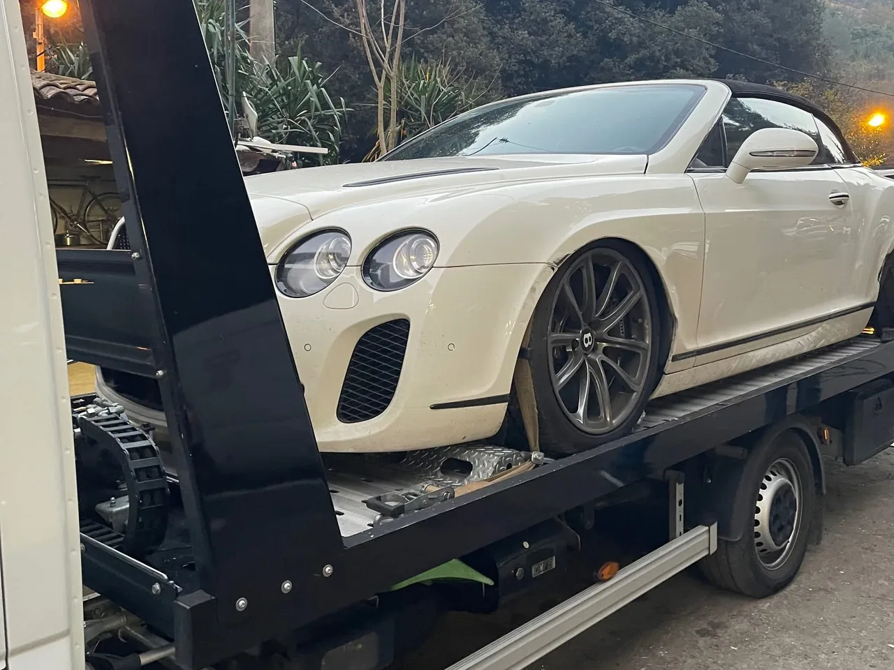 Bentley Continental GTC blanche chargée sur une dépanneuse plateau, vue avant