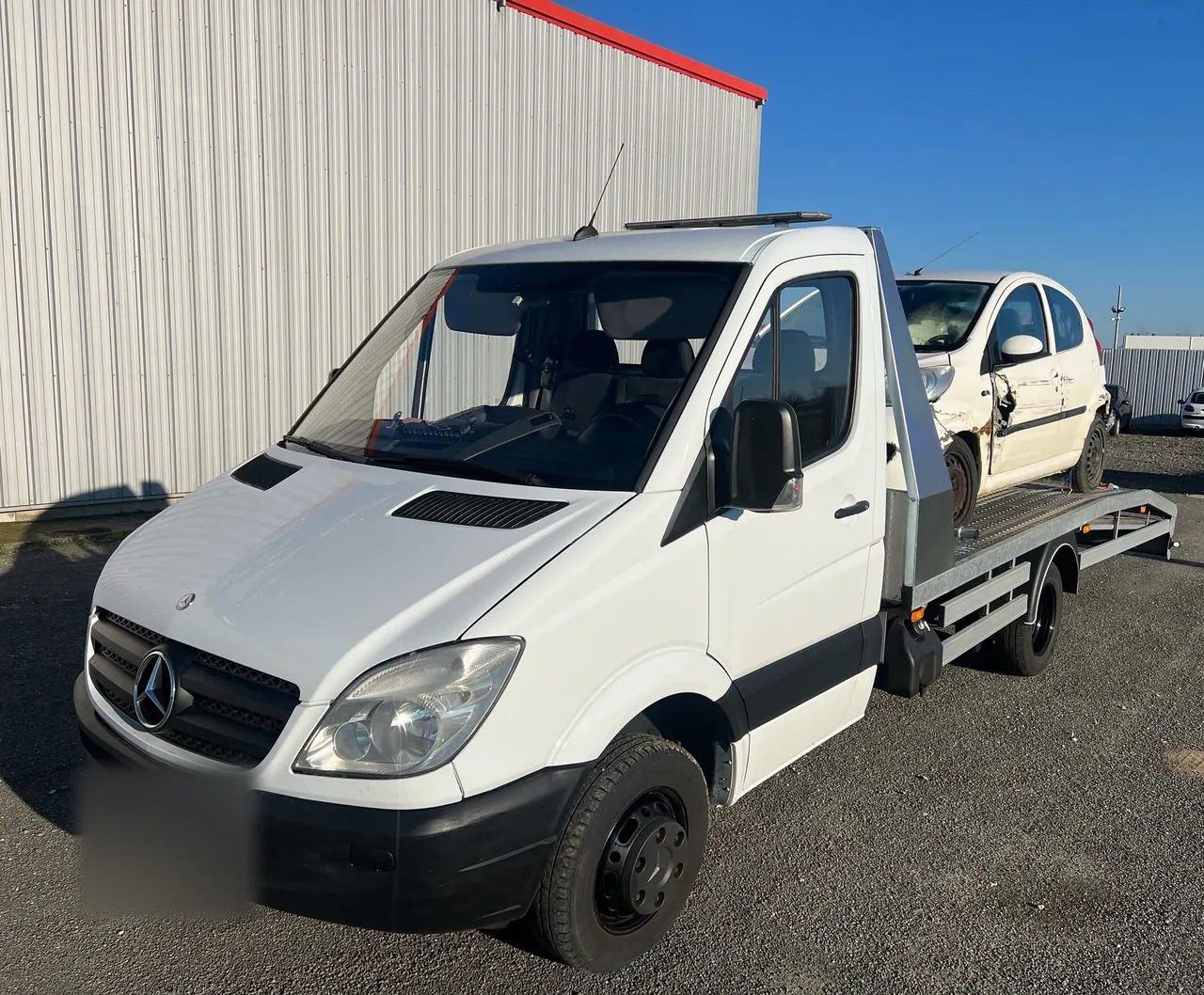 Peugeot 107 accidentée chargée sur une dépanneuse plateau Mercedes Sprinter