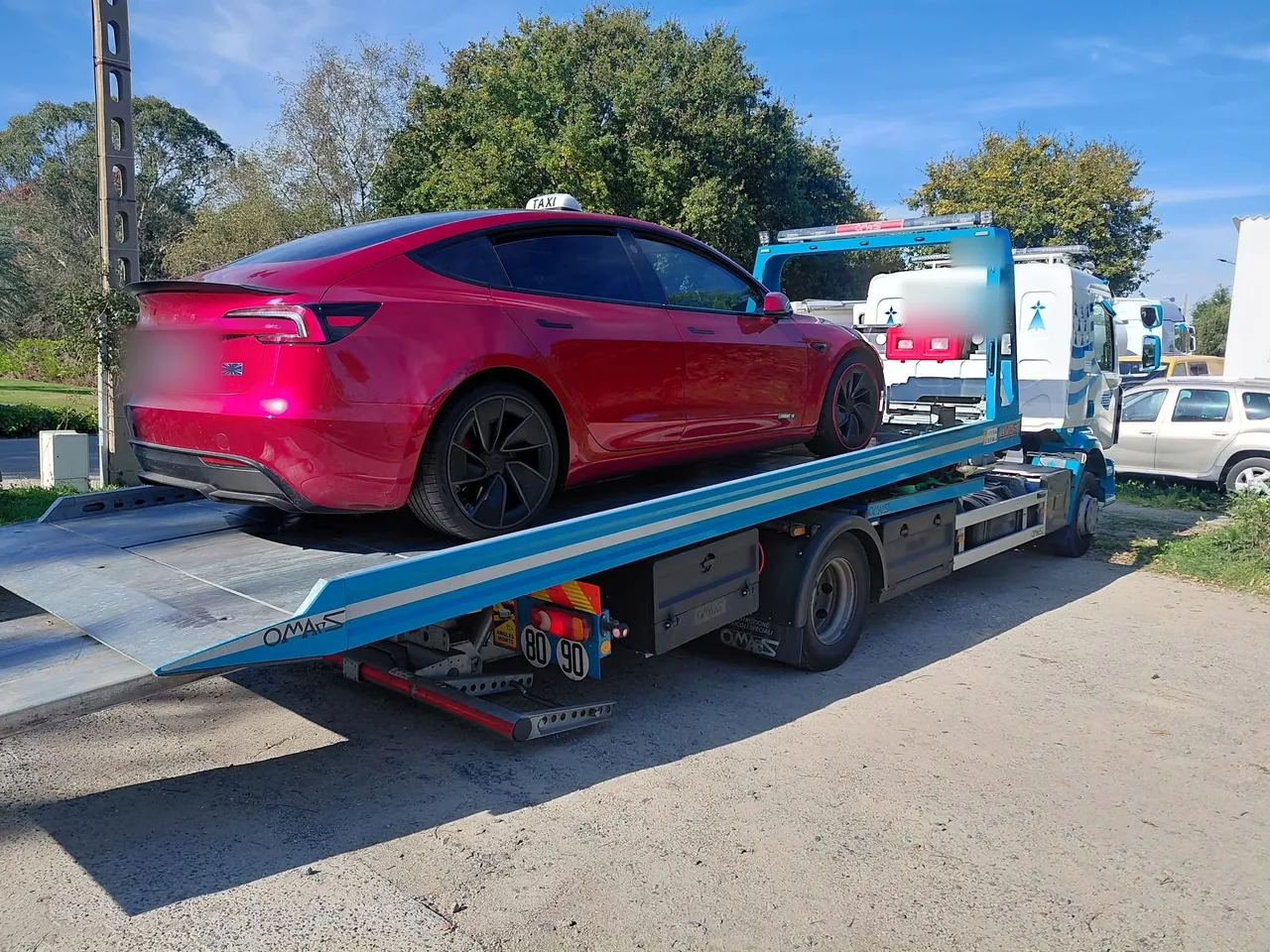 Taxi Tesla Model 3 chargé sur un camion plateau de dépannage dans le Finistère