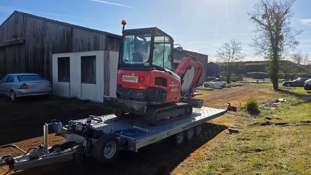 Mini-pelle Kubota KX027-4 transportée sur plateau porte-engin