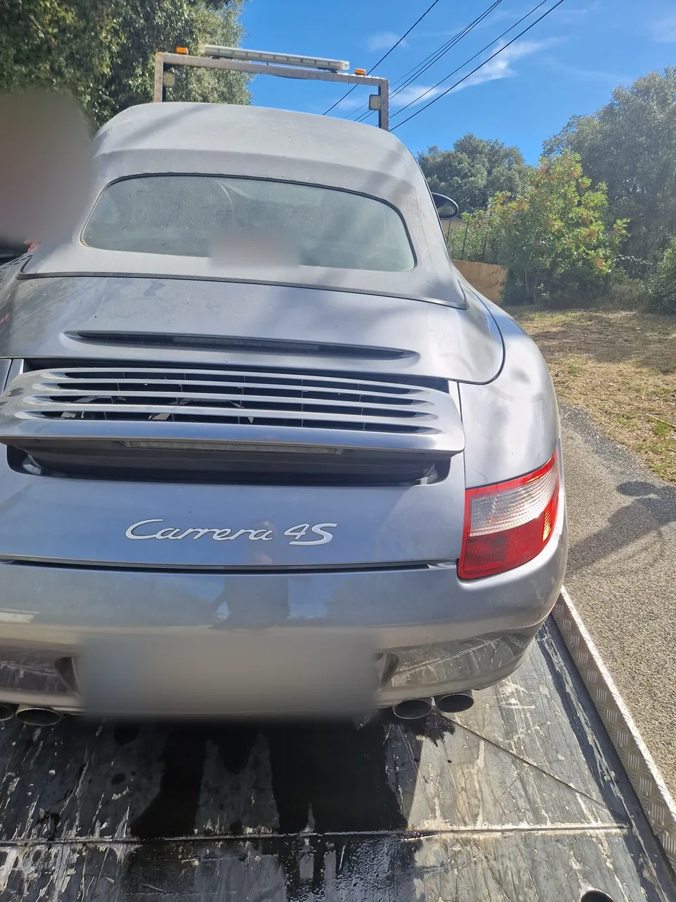 Porsche 911 Carrera 4S grise chargée sur un plateau de dépannage